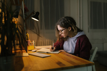 Young woman studying from home at night 