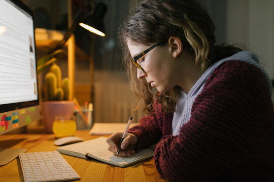Young woman studying from home at night 