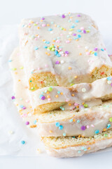 Obraz na płótnie Canvas A sliced loaf of confetti cake ready for serving against a bright white background.