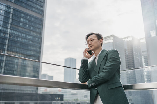 Man Stand In Front Of City Buildings And Make A Phone Call