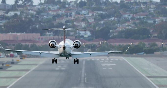 Cinematic close up back view on landing airplane. Small jet arriving at airport 