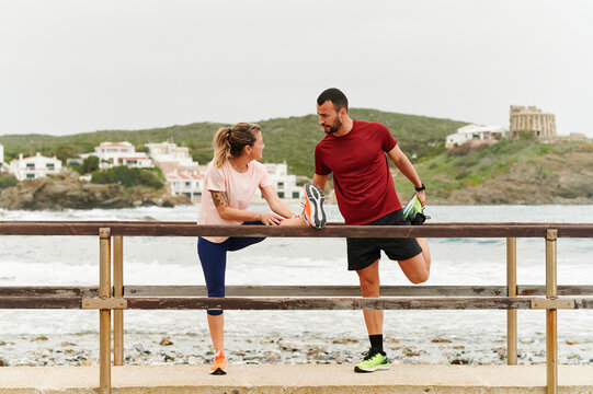 Couple stretching on a bridge before a run