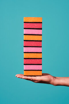 man holds a pile of kitchen sponges in hs hand