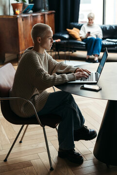 Young woman using laptop at home office.