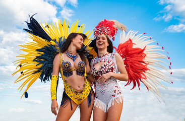 Two pretty samba dancers having fun and laughing, focus on girl in yellow 