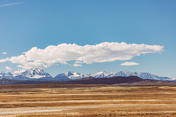 Arid plains against Sierra Nevada Mountains and clear blue sky 