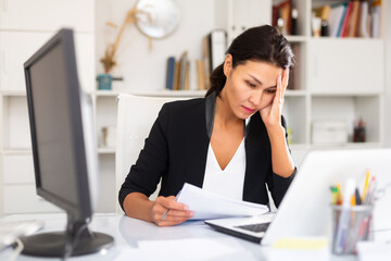 Fototapeta premium Tired businesswoman working with documents in business office