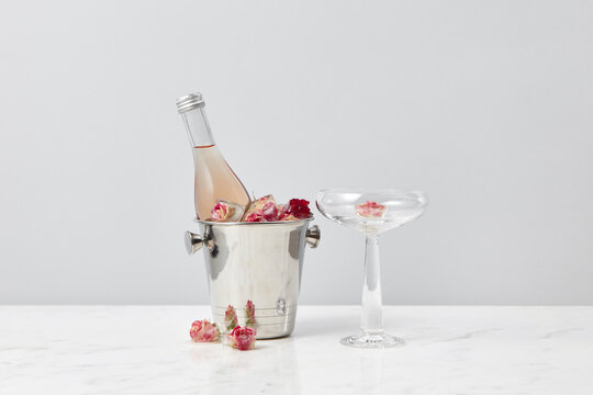 Bottle in bucket and roses in ice cubes