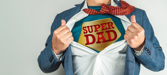 Man in a suit who opens his shirt and tie to become a super hero, super dad. Father's day concept