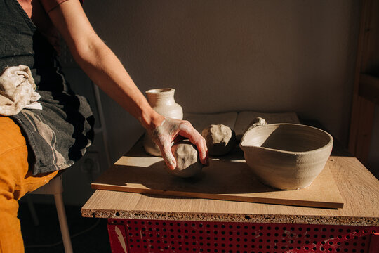 Hand of a potter taking a piece of clay for work