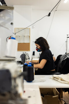 Young woman working with sewing machine