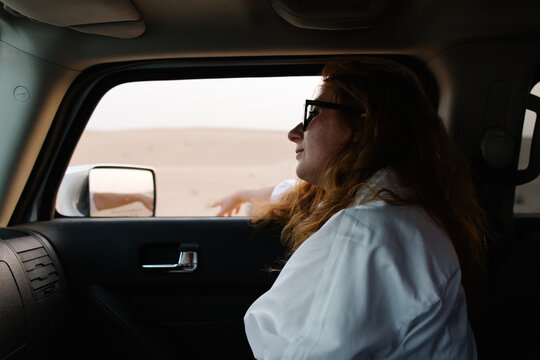 A woman in a car enjoying the view
