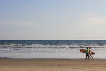 Fototapeta na wymiar Surfers caminando por la playa