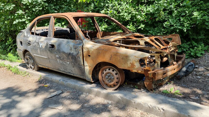 a car stands on the side after a fire. vandalism and damage to property.