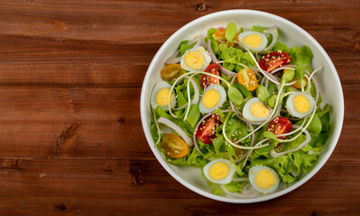 Big white bowl full of lettuce, sprout salad with boil egg, onion and tomato mixed with Japanese sesame balsamic vinegar dressing on brown wooden table