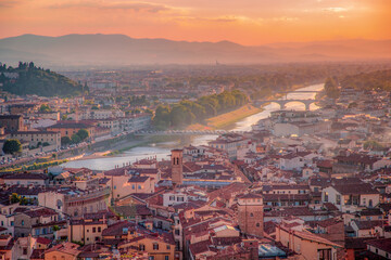 Naklejka premium Florence, Italy - 20 June, 2019 : panoramic overview from Arnolfo Tower (Torre di Arnolfo)at sunset haze, historical part of the city, River Arno and mountains range in sunset rays on the background 