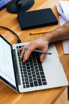 Unrecognizable man typing on laptop keybord