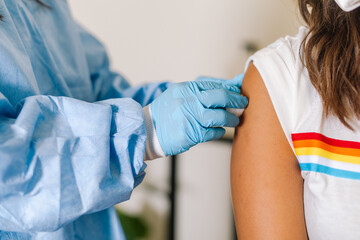 Crop nurse preparing arm of patient for injection