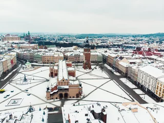 Fotobehang Aerial view of the Town hall tower in the old square of Krakow. Poland. City with ancient architecture. Historic buildings. City skyline during the daytime. Winter season. Clear sky in the background © CameraCraft