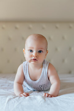 Blue eye baby is lying on the bed