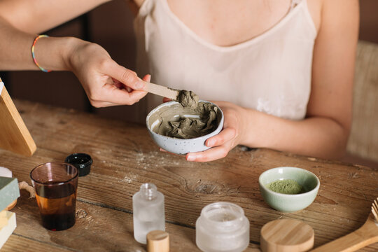Closeup Of A Young Woman Making Green Clay Mask