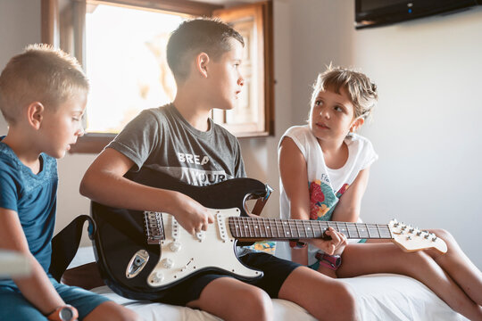 Siblings learning to play the electric guitar, home schoolingtogether