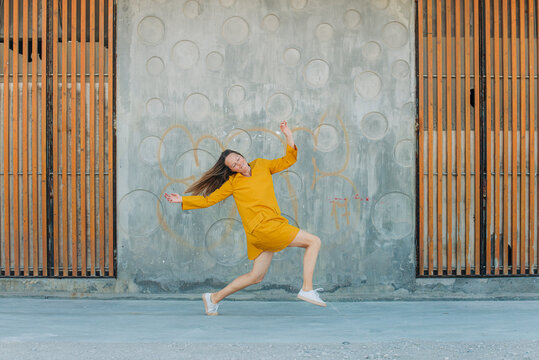 Blonde girl in yellow in a dancing pose