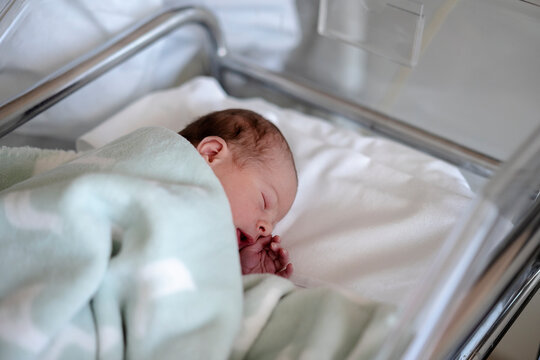 Newborn baby sleeping relaxed in an incubator