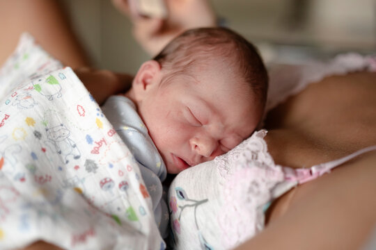 Newborn sleeping on his mother's lap
