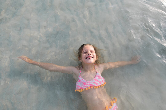 Portrait of a little girl in the sea smiling
