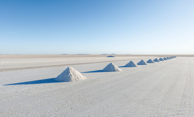 Salt mining in Colchani with salt pyramids ready for harvest, Uyuni salt flat (Salar de Uyuni),...