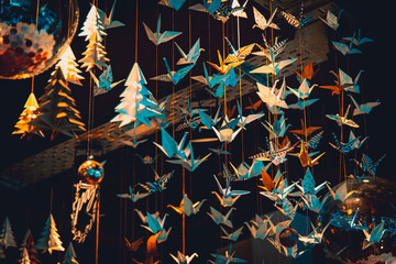 Lots of origami swans hanging from the roof, seen from underneath in a softly illuminated room