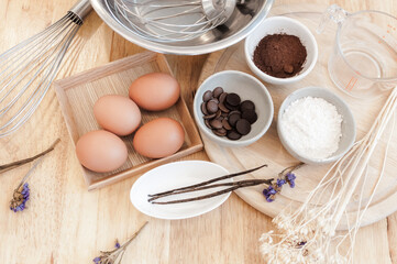 Fototapeta na wymiar Top View Baking Preparation on wooden Table,Baking ingredients. Bowl, eggs and flour, rolling pin and eggshells on wooden board,Baking concept