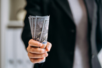 close up view of businesswomen gripping dollars banknote, cash flow, income, financial and business success concept.