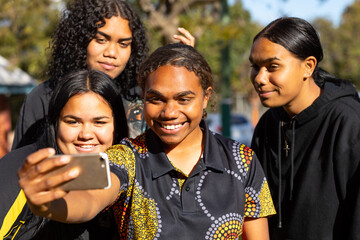 group of teen girls posing for selfie outdoors