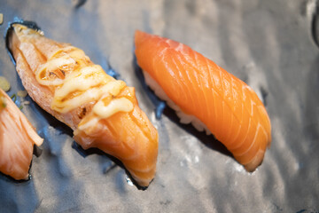 Burnt salmon sushi with mayoungnes sauce and fresh salmon sushi served on plate