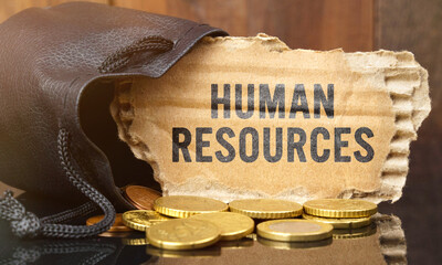 On the table is a bag of money from which sticks out cardboard with the inscription - HUMAN RESOURCES