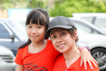 Asian daughter put her arm on her mother's shoulder