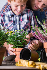 Child helps to father planting flowers. Family time at home