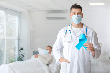 Oncologist with blue ribbon in clinic. Prostate cancer awareness concept