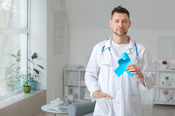 Oncologist with blue ribbon in clinic. Prostate cancer awareness concept