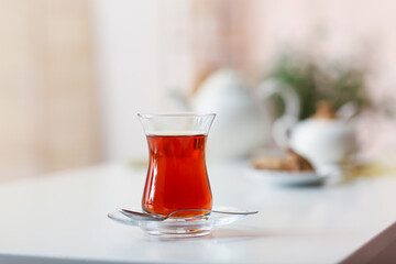 Glass with hot Turkish tea on table in kitchen