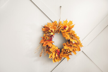 Beautiful autumn wreath hanging on grey wall