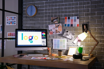 Comfortable workplace of graphic designer in office at night