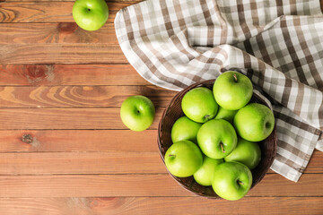 Basket with fresh green apples on table