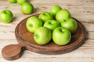 Board with fresh green apples on table