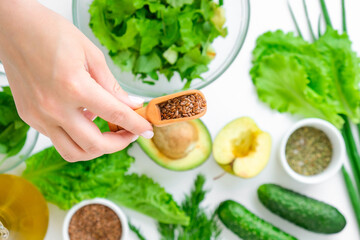 Woman cooking salad of fresh green vegetables and herbs. Cooking healthy diet or vegetarian food....