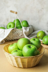 Basket with fresh green apples on table