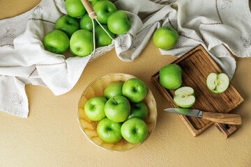 Fresh green apples with cutting board and knife on color background