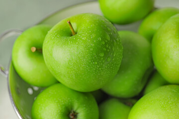 Colander with fresh green apples, closeup